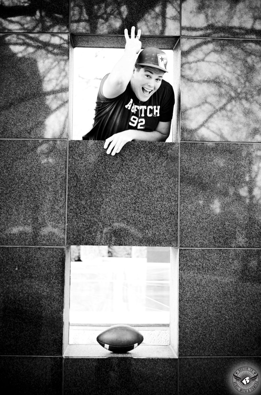 Senior photographers in Austin take picture of class clown football player at the Texas State Capitol.